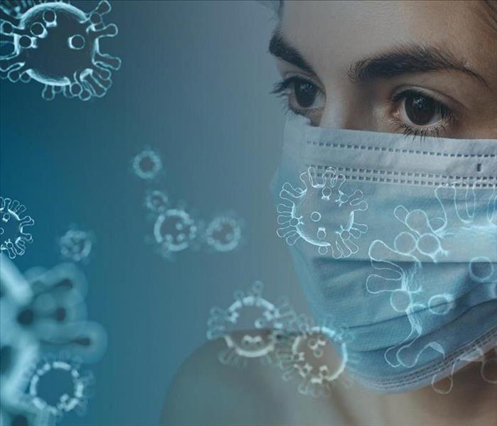 women with facial mask surrounded by graphic symbols of coronavirus