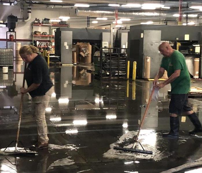 Two SERVPRO of Fernandina Beach/Jacksonville Northeast technicians cleaning up flooding at a Jacksonville warehouse.