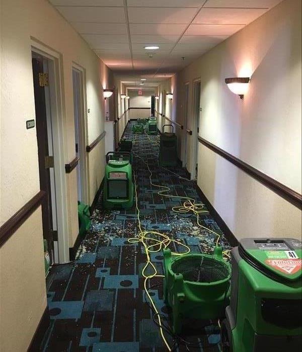 Hotel hallway outside water damaged guest rooms before extraction and drying take place.